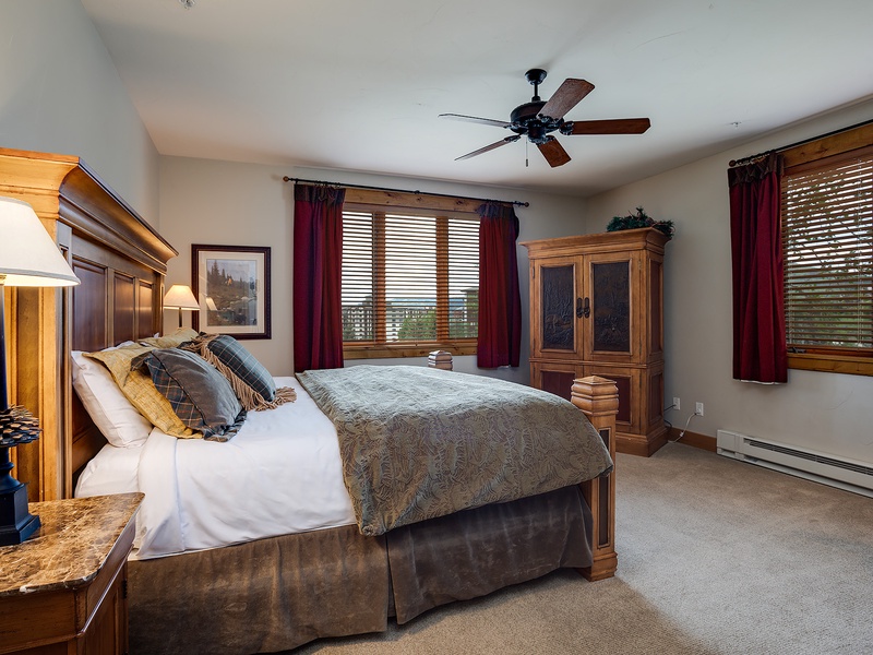 Slip into your peaceful retreat with a plush bed, warm wood furnishings, and soft natural light filtering through the windows. Your cozy escape awaits.