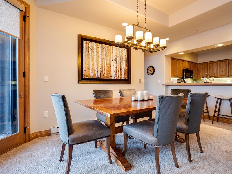 Gather around this inviting dining table where you'll share meals and memories with loved ones. The warm wood tones and soft lighting create the perfect atmosphere for your mountain retreat.