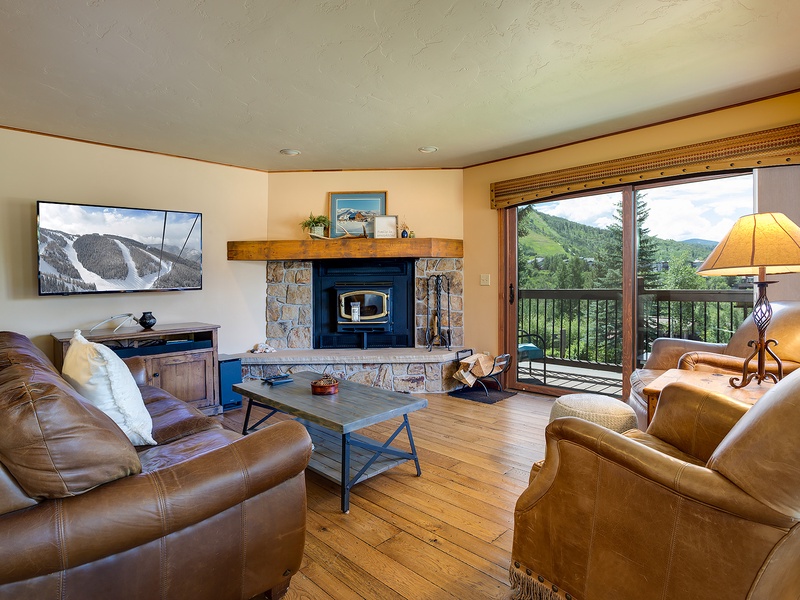 Sink into plush leather seating and enjoy mountain vistas through your private balcony. The cozy fireplace and rustic wood floors create the perfect alpine retreat after your adventures.
