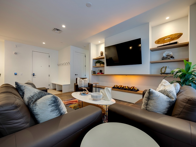 Sink into plush seating and unwind by the sleek fireplace. This modern living space welcomes you with coastal-inspired décor, warm ambient lighting, and all the comforts you need to relax after a day of exploring.