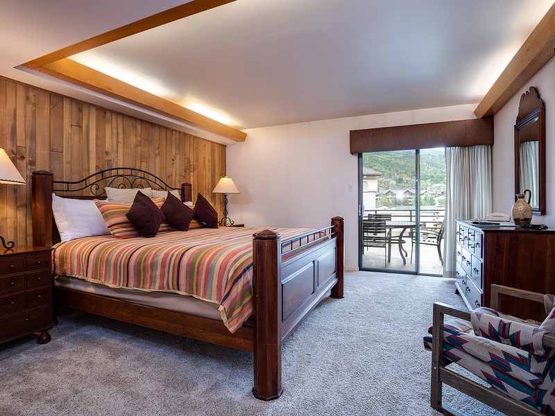 Drift off in this cozy bedroom with warm wood accents, ambient lighting, and your own private balcony overlooking peaceful mountain views.