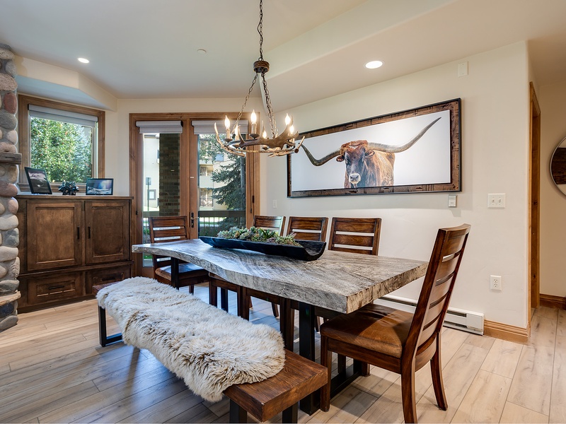 Gather around this stunning live-edge table where rustic elegance meets mountain charm—your group dinners will feel like special occasions under the warm chandelier glow.
