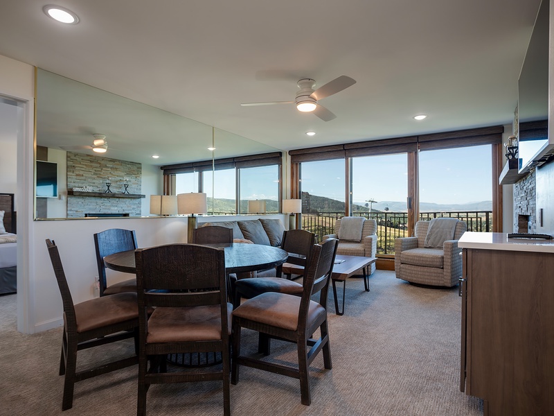 Floor-to-ceiling windows frame sweeping mountain vistas in this open-concept living space, where your dining and lounge areas flow seamlessly together, inviting relaxation and connection with nature's grandeur outside.