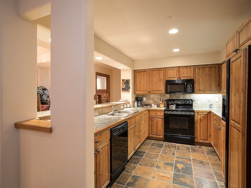 Your fully equipped kitchen features warm wood cabinetry, granite counters, and modern appliances—everything you need to prepare delicious meals during your stay.