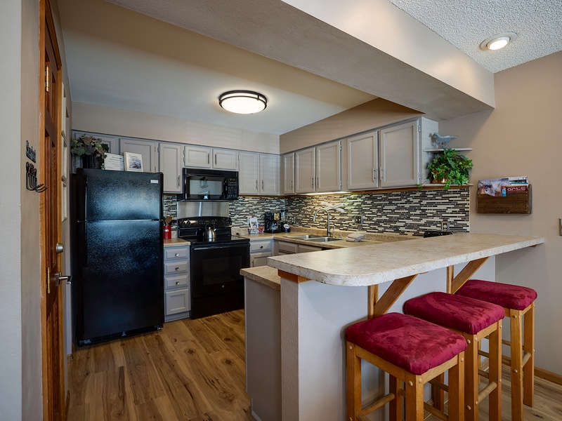Your fully equipped kitchen features modern appliances, elegant backsplash, and a breakfast bar where you can savor morning coffee with family or prep meals together.