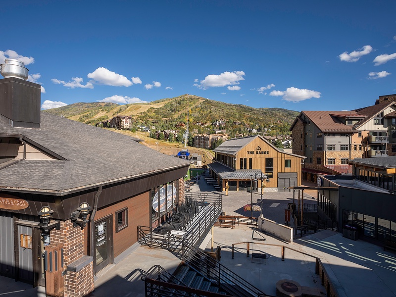 Mountain town setting with village shops and restaurants within walking distance, surrounded by scenic hills and clear blue skies.