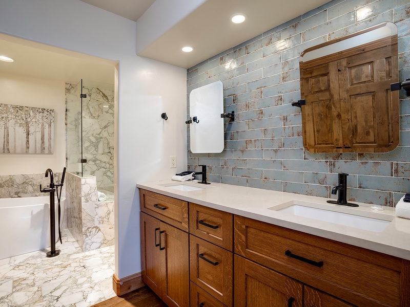 Unwind in your serene spa-like bathroom, featuring dual sinks, elegant tile work, and a luxurious soaking tub perfect for relaxing after a day exploring.