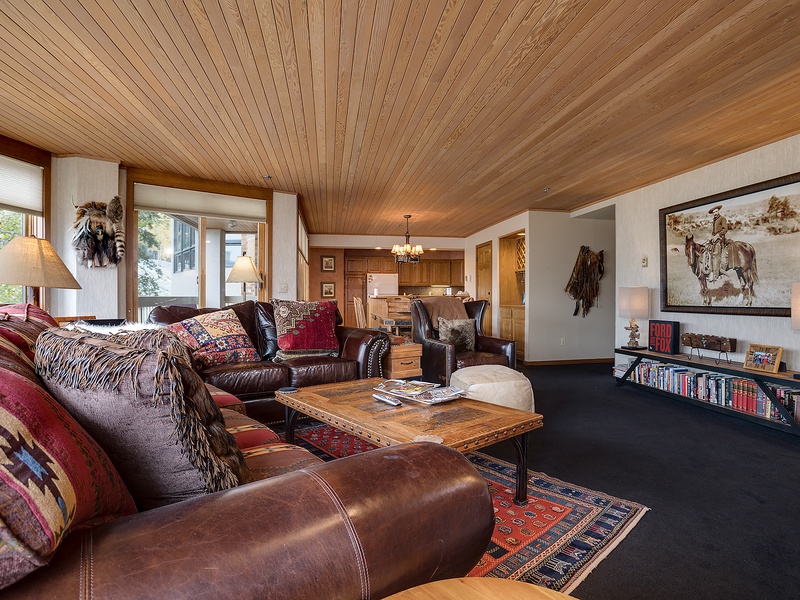 Sink into rich leather sofas under warm wood-paneled ceilings, where rustic artwork and cozy textiles create your perfect mountain retreat for relaxation and togetherness.