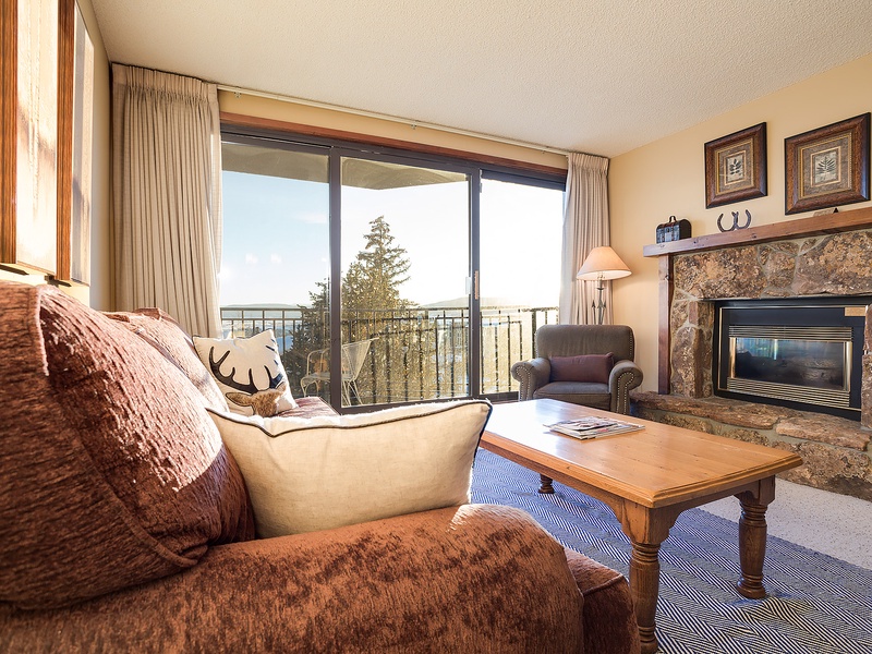 Curl up by your cozy stone fireplace after a day of adventure. Floor-to-ceiling windows invite natural light while plush seating and mountain charm create your perfect retreat.