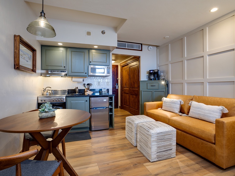 Settle into your cozy open-plan retreat with a vibrant mustard sofa, fully equipped kitchen, and warm wood tones that create the perfect home away from home.