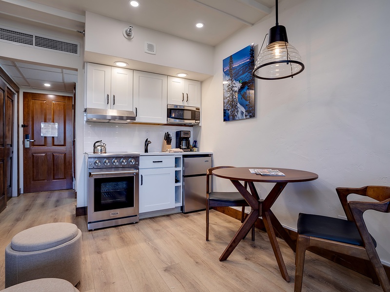 Your stylish open-concept suite features a fully equipped kitchen with stainless appliances, cozy dining nook, and modern air-conditioned comfort for relaxing mountain getaways.
