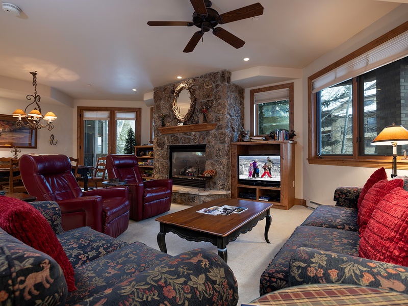Sink into plush seating by the stone fireplace, where you can unwind after your mountain adventures with your favorite shows and cozy warmth.