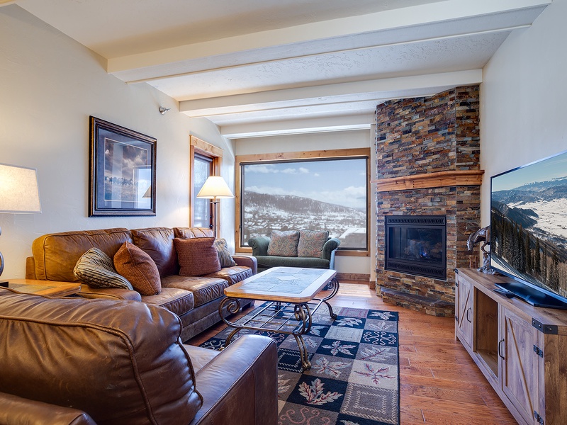 Sink into plush leather sofas by the stone fireplace and enjoy breathtaking mountain views through expansive windows—your perfect retreat after a day of adventure.
