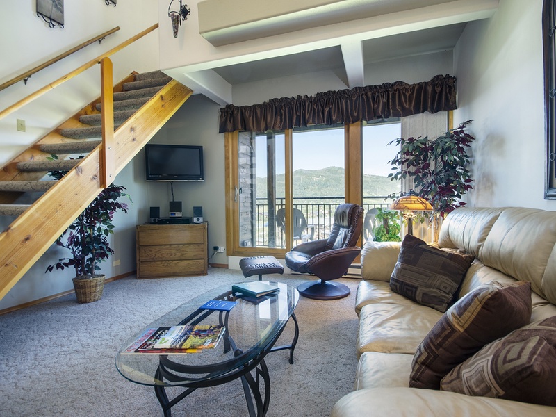 Sink into plush seating and soak up mountain vistas from your private balcony. This inviting loft-style living room blends cozy warmth with breathtaking natural beauty, perfect for your mountain escape.