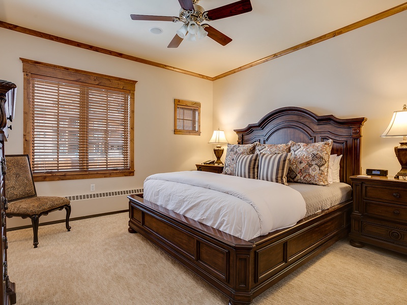 Sink into crisp linens and plush pillows in your elegant bedroom, where warm wood tones and soft lighting create a peaceful retreat for restful nights.