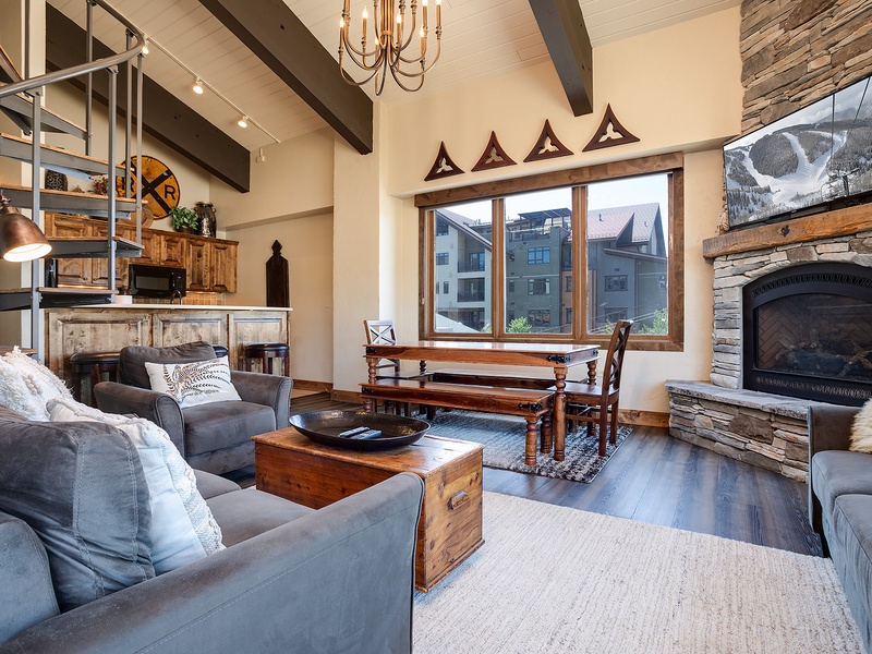 Gather around the roaring fireplace in your cozy living room, where rustic elegance meets mountain charm. Vaulted ceilings, exposed beams, and plush seating create the perfect retreat after a day exploring the slopes.