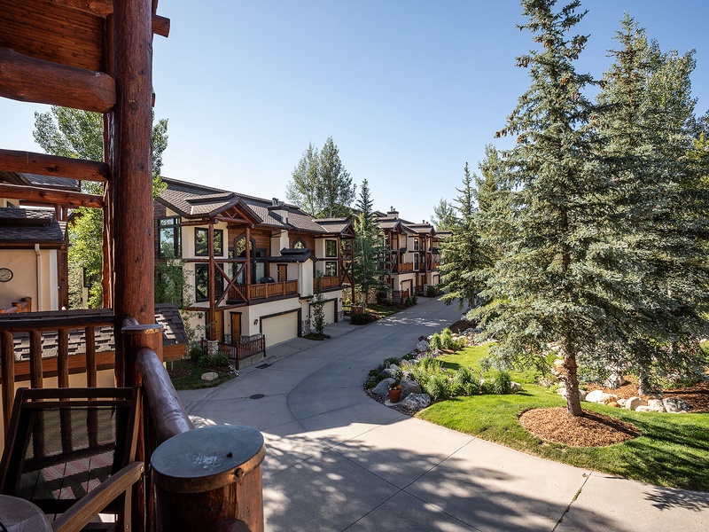 Mountain resort community featuring contemporary alpine architecture, mature evergreen trees, landscaped grounds, and a peaceful residential setting with multi-level homes and private access roads.