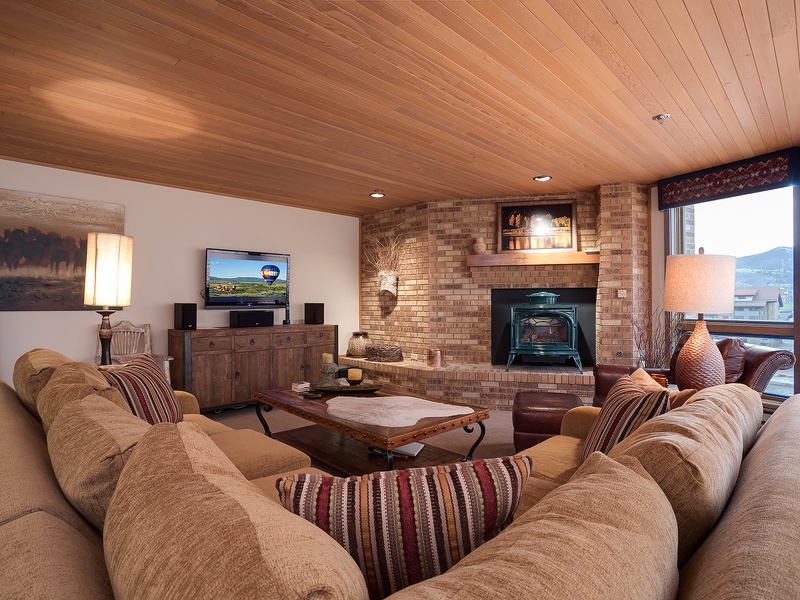 Sink into plush seating and unwind by the cozy fireplace in your spacious living room, where warm wood tones and mountain views create your perfect retreat.