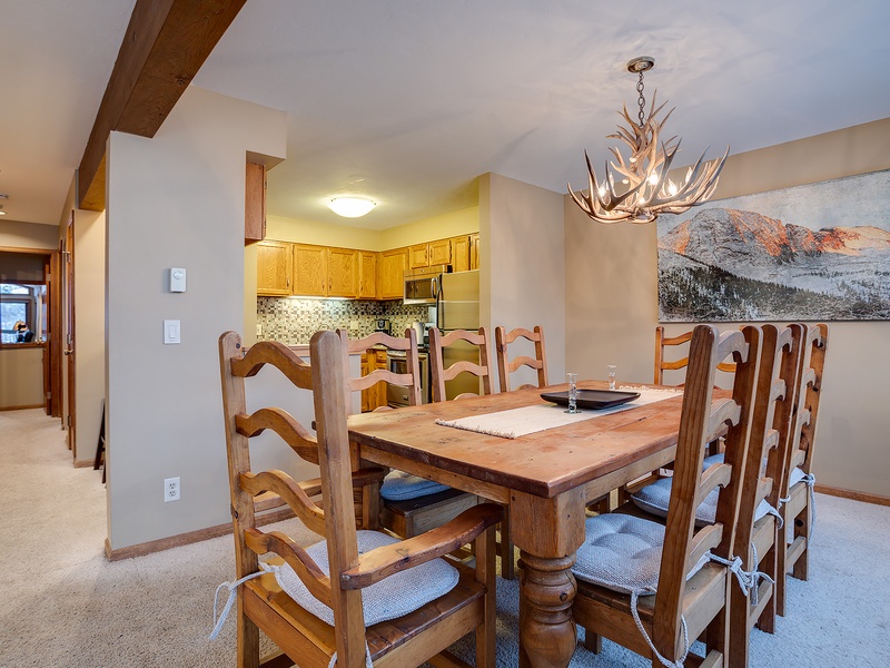 Gather around this inviting rustic table where your group can share meals and stories under the warm glow of a striking antler chandelier, with mountain views setting the perfect alpine backdrop.
