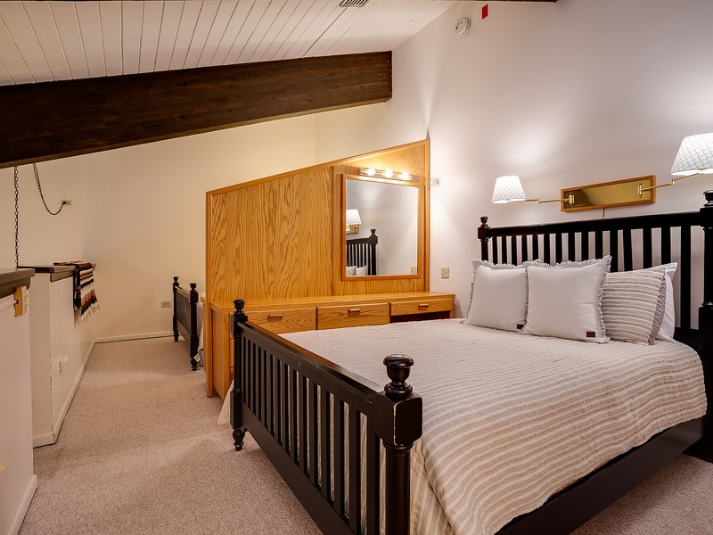 Retreat to your cozy loft bedroom with rustic wooden beams overhead and plush bedding inviting you to unwind after a day of adventure.