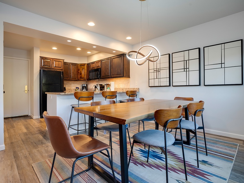 Gather around the spacious dining table where your group can share meals and laughter together, with a fully equipped kitchen just steps away for all your culinary adventures.