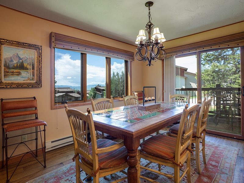 Gather around a warm dining space where lake views and mountain scenery frame your meals. Large windows invite natural light while you enjoy cozy conversations and mountain living at its finest.