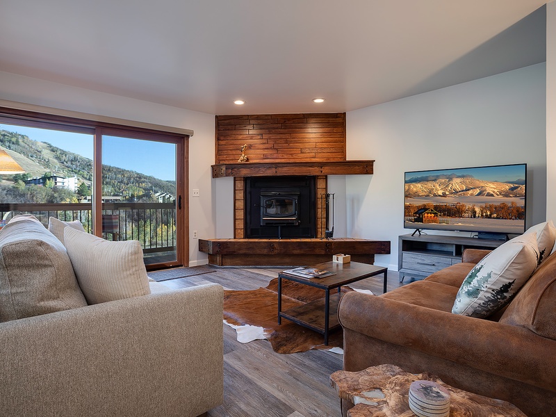 Relax by the fireplace and mountain views in your cozy living room. Plush seating, warm wood accents, and a modern TV await.