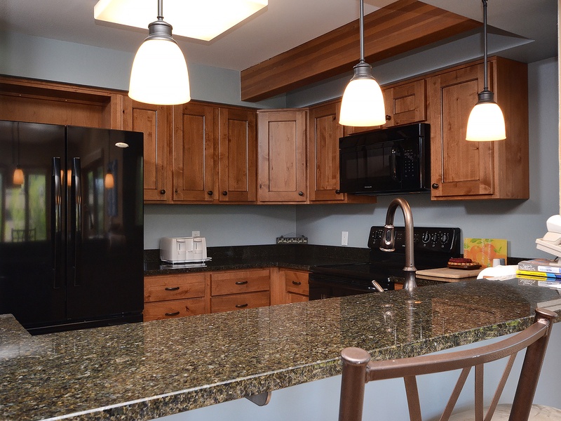Your fully equipped kitchen features rich wood cabinetry, granite countertops, and modern appliances—perfect for preparing meals together while enjoying the open, inviting layout.