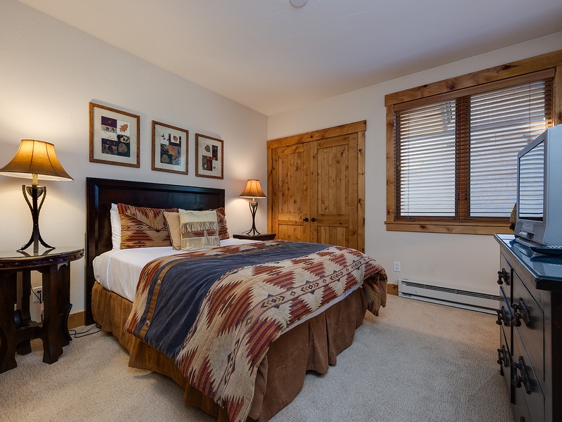 Sink into the plush bedding and rustic warmth of your private retreat, where soft lighting and mountain views promise restful nights after days of adventure.