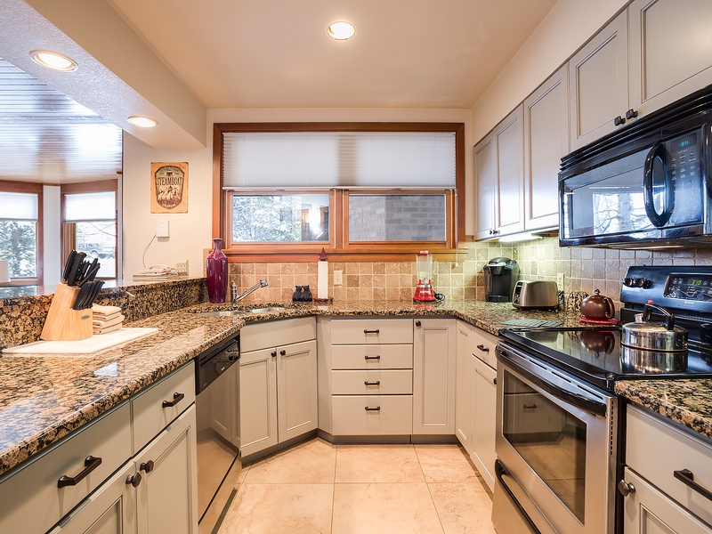 Your well-appointed kitchen awaits, featuring gleaming granite countertops, stainless appliances, and abundant storage. Natural light pours in as you prepare meals in this spacious, comfortable cooking space.