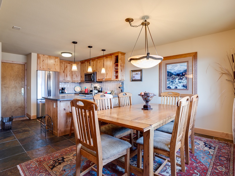 Gather around this handsome dining table with mountain views and a fully equipped kitchen at your fingertips. The warm wood tones and open layout make mealtime feel like home.