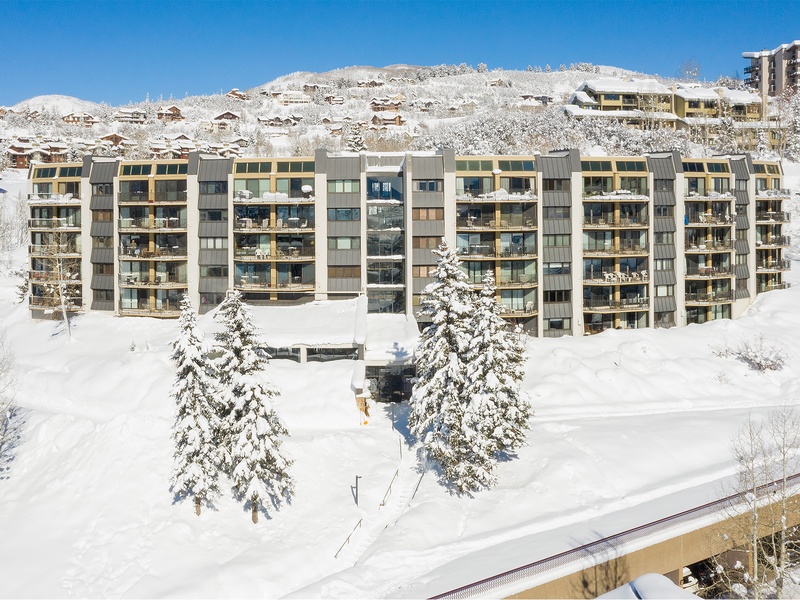 Modern apartment complex nestled in pristine alpine surroundings, offering direct access to winter activities in a scenic mountain resort village.
