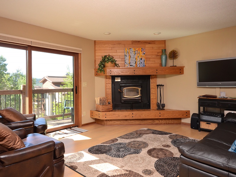 Unwind in your spacious living room, where sunlight streams through the balcony doors and a cozy fireplace invites you to relax after a day of adventure.