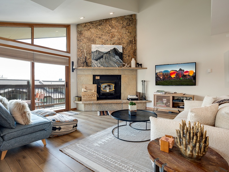 Sink into plush seating by your private stone fireplace, where mountain views frame cozy evenings and modern comforts create your perfect retreat.