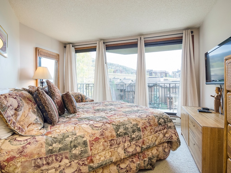 Wake up to stunning mountain views from your cozy bedroom. The large windows frame the slopes, while soft lighting and comfortable furnishings create a peaceful retreat after a day of adventure.