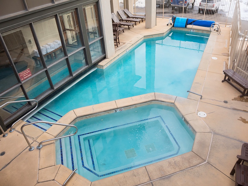 The indoor pool area offers year-round swimming and relaxation, with a warm hot tub nearby and plenty of lounge chairs lining the deck for your ultimate comfort.