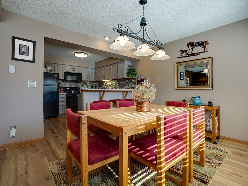 Gather around this inviting dining table where sunlight streams across rich wood and plush seating. With a fully equipped kitchen steps away, your meals together will feel warm and memorable.