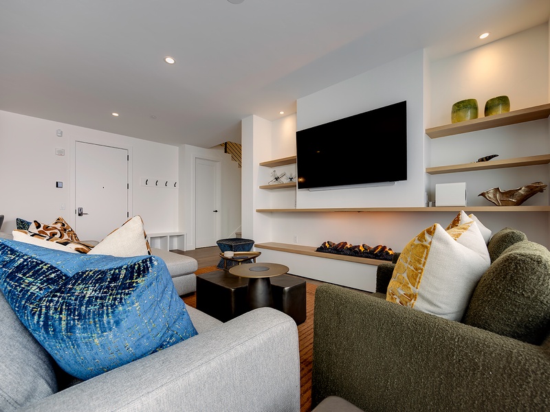 Sink into plush seating and unwind in your stylish living area, complete with a cozy electric fireplace and modern entertainment setup for relaxing evenings in.