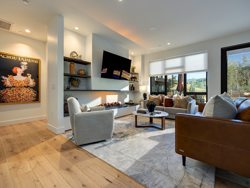 Unwind in your light-filled living room, where sleek built-ins and a cozy fireplace set the stage for relaxing evenings with mountain views just beyond the windows.