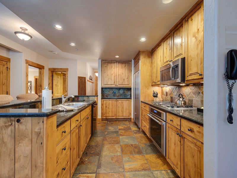 Step into your fully equipped kitchen with granite countertops, modern appliances, and a spacious layout perfect for preparing memorable meals during your stay.