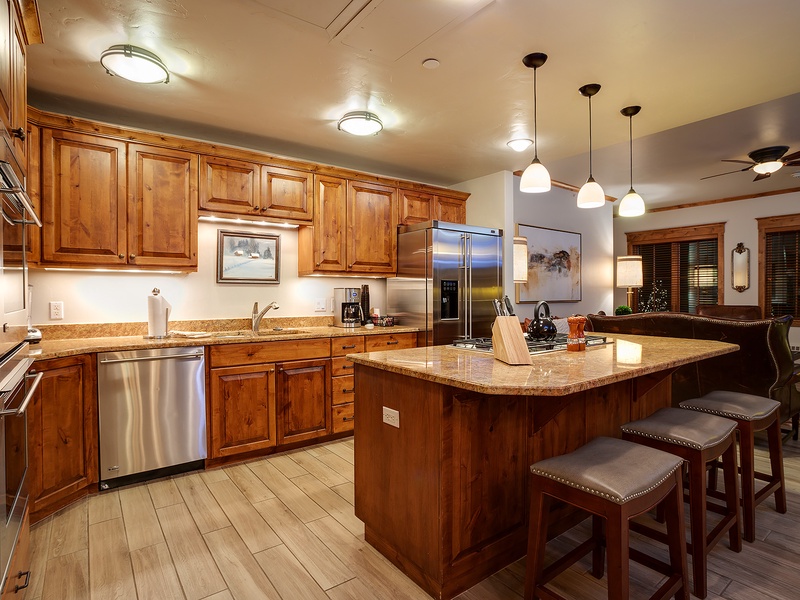 Your gourmet kitchen awaits with rich wood cabinetry, granite countertops, stainless steel appliances, and a spacious island where you can gather to cook and share memorable meals together.