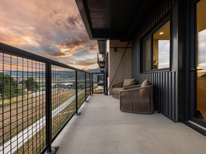 Settle into your private balcony as the sky transforms into soft shades of peach and gold. The cozy seating invites you to unwind, while mountain silhouettes rise in the distance—perfect for morning coffee or evening reflections.