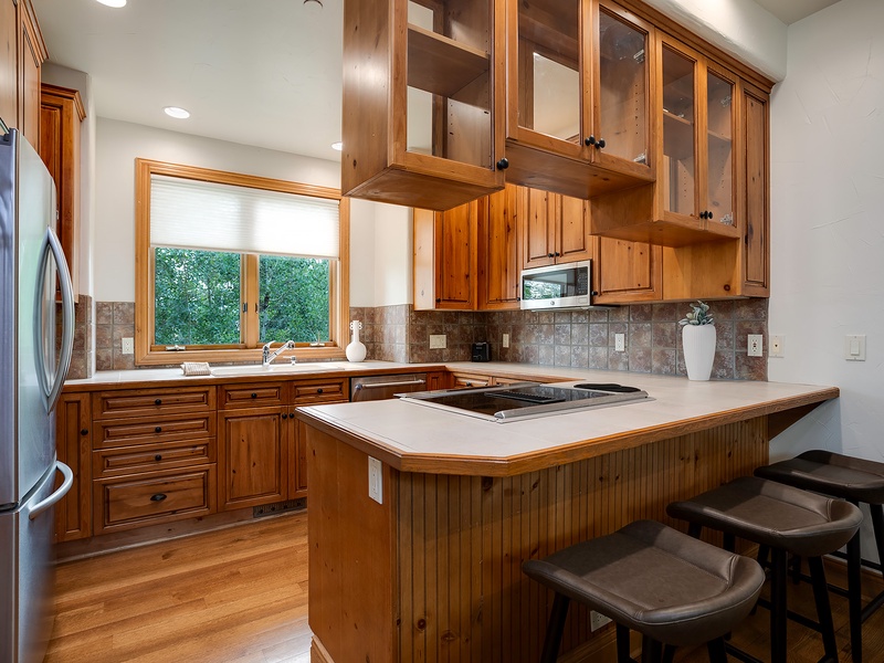 Prepare home-cooked meals in your spacious kitchen with rich wood cabinetry, modern appliances, and an inviting island where you can gather with loved ones.