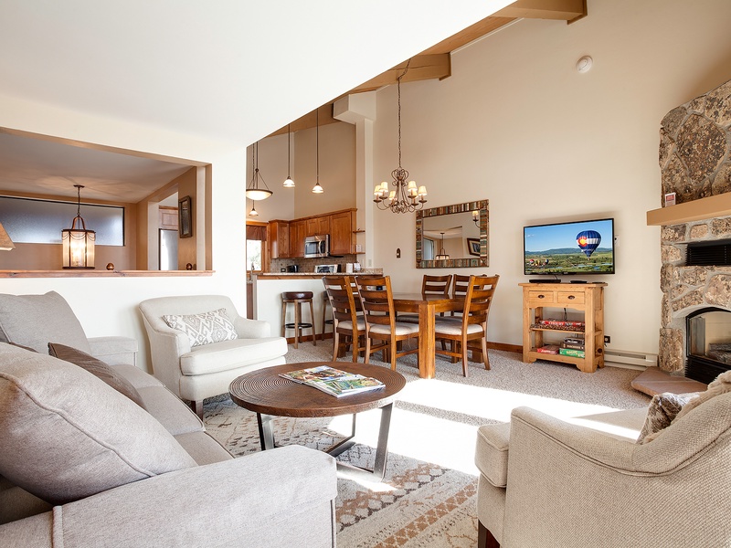 Relax in your bright, open living area with soaring ceilings, cozy stone fireplace, and plush seating perfect for gathering after a day of adventure.