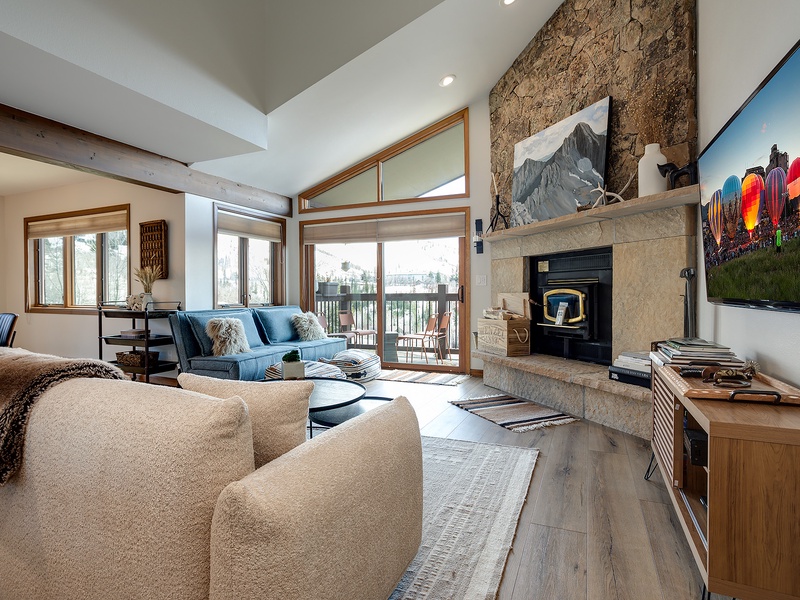 Sink into plush seating by your stone fireplace, let natural light pour through floor-to-ceiling windows, and enjoy soaring ceilings that make your alpine retreat feel open and inviting.