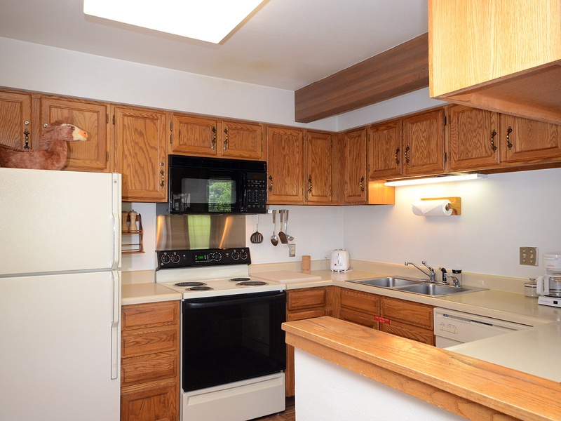 Your well-equipped kitchen features oak cabinetry, full-size appliances, and generous counter space—perfect for preparing your morning coffee or family meals in comfort.