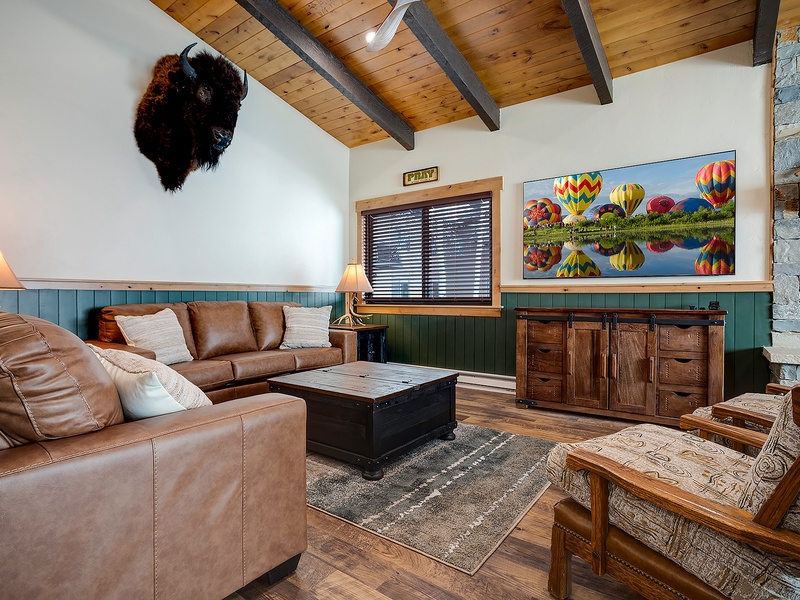 Sink into plush leather sofas beneath soaring wood-beam ceilings, where rustic charm meets colorful mountain décor. Your cozy retreat awaits, complete with unique character and inviting warmth.