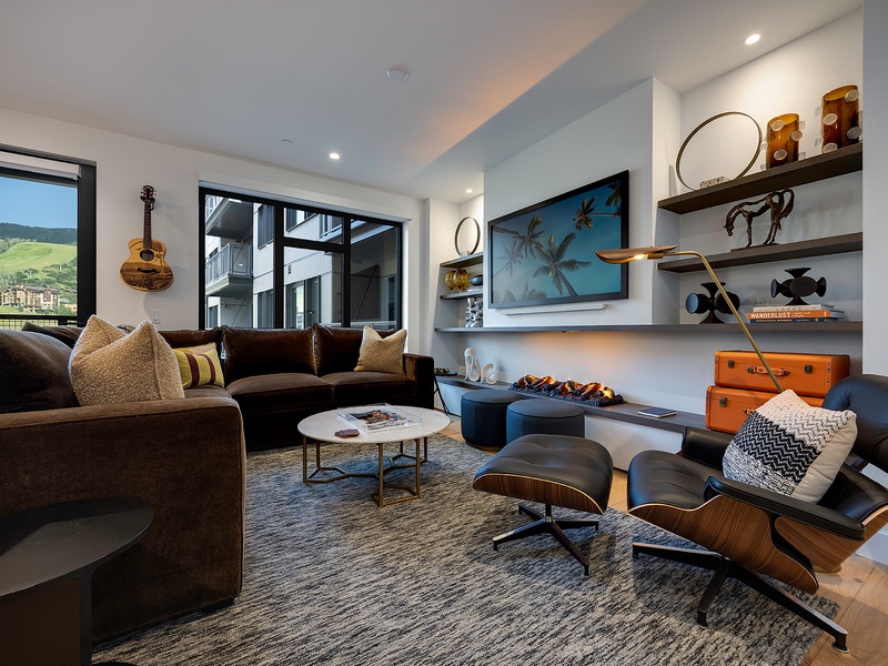 Sink into the plush sectional or curl up in the Eames lounge chair as natural light floods this inviting living space. Your mountain escape awaits with stylish comfort and thoughtful touches throughout.