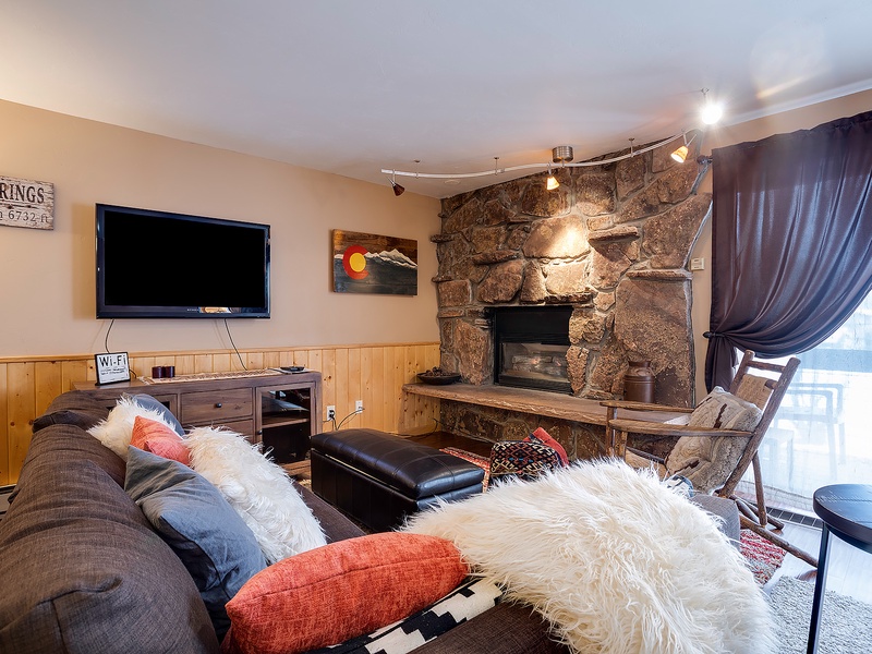 Curl up on the plush sofa with cozy throws and sink into your perfect mountain retreat, where a rustic stone fireplace adds warmth and charm to your relaxing evenings together.