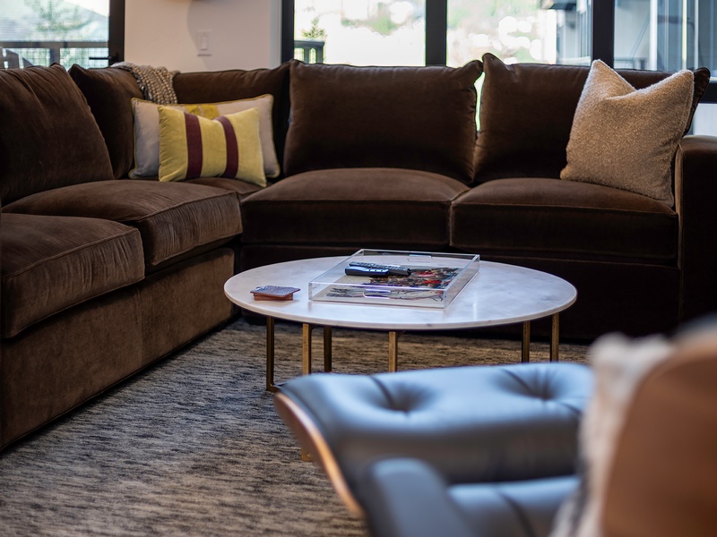 Sink into plush velvet sofas and unwind in your bright living room, where a marble coffee table holds your favorite reads and windows frame soft natural light for cozy afternoons.